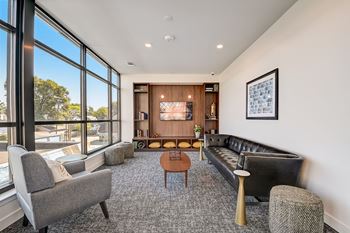 a living room with couches chairs and a coffee table in front of a large window